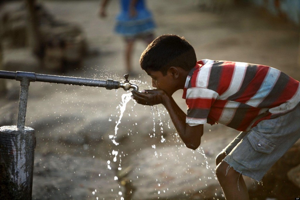 An Indian boy drinks water from a roadside tap on the eve of World Water Day in Allahabad, India, Thursday, March 21, 2013. The U.N. estimates that more than one in six people worldwide do not have access to 20-50 liters (5-13 gallons) of safe freshwater a day to ensure their basic needs for drinking, cooking and cleaning. (AP Photo/ Rajesh Kumar Singh)